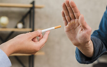 Person refusing a cigarette with an outstretched hand.