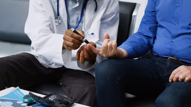 A healthcare professional, wearing a white coat and stethoscope, is using a glucose meter to check the blood sugar level of a patient in a blue shirt, who is seated beside them with an extended finger.